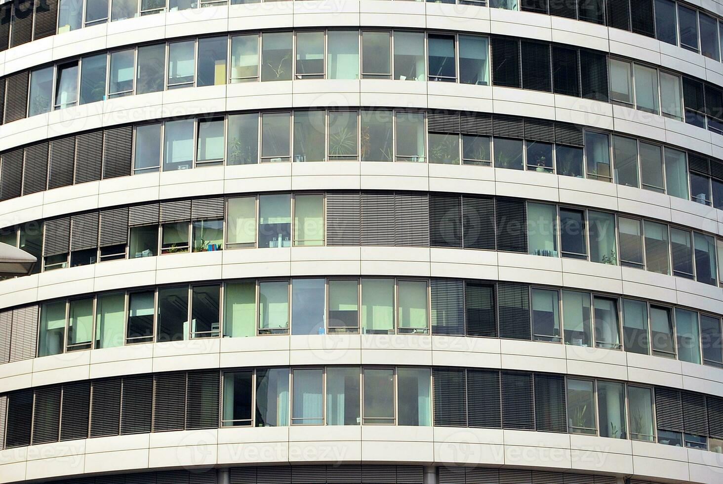 Abstract closeup of the glass-clad facade of a modern building covered in reflective plate glass. Architecture abstract background. Glass wall and facade detail. photo