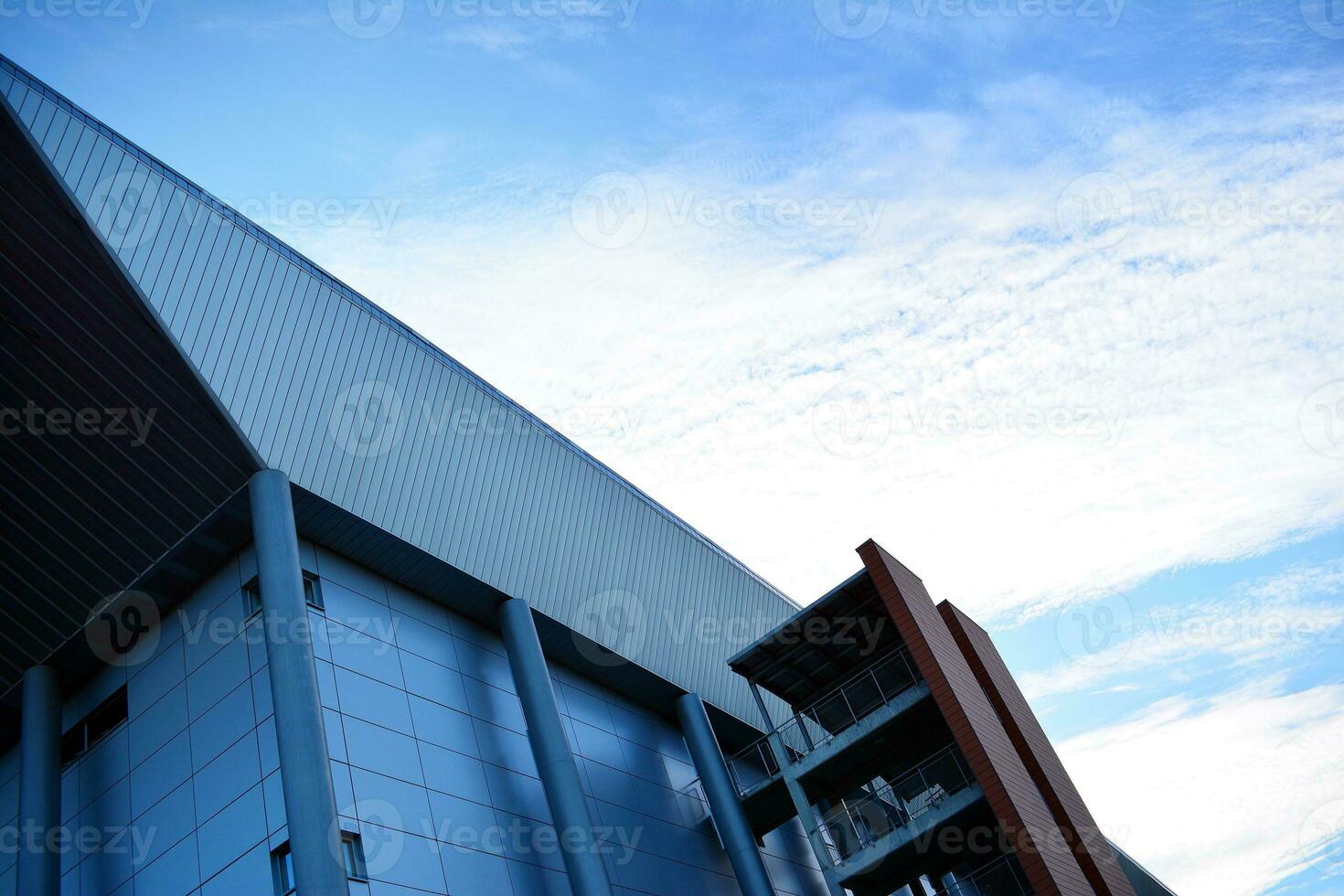 Abstract closeup of the glass-clad facade of a modern building covered in reflective plate glass. Architecture abstract background. Glass wall and facade detail. photo