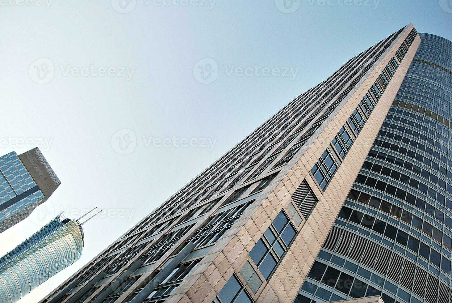 Abstract closeup of the glass-clad facade of a modern building covered in reflective plate glass. Architecture abstract background. Glass wall and facade detail. photo