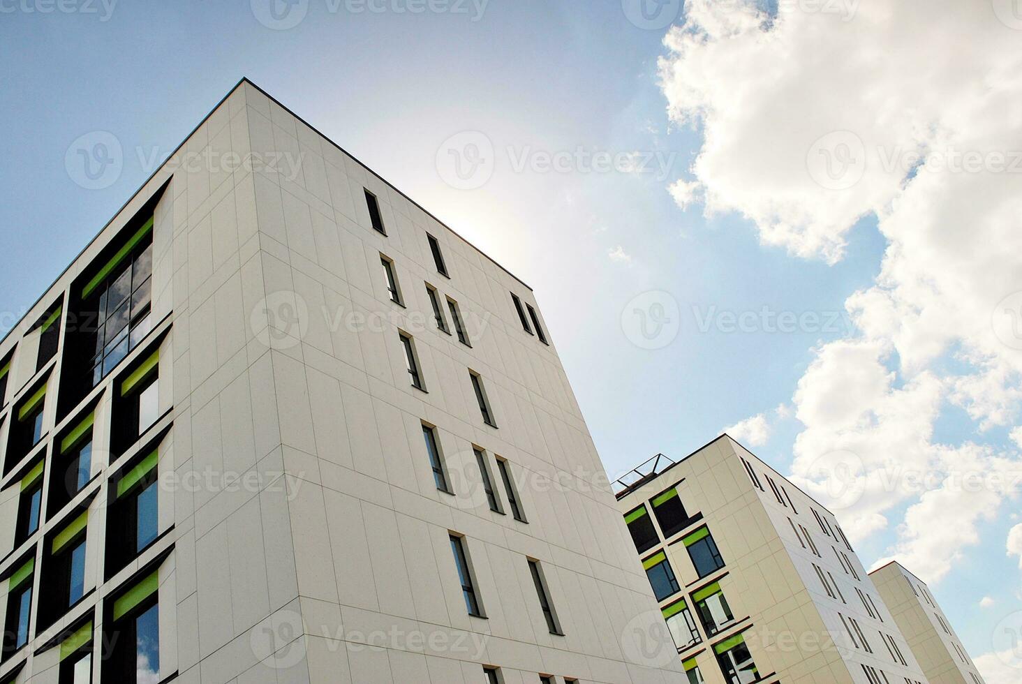 Abstract closeup of the glass-clad facade of a modern building covered in reflective plate glass. Architecture abstract background. Glass wall and facade detail. photo