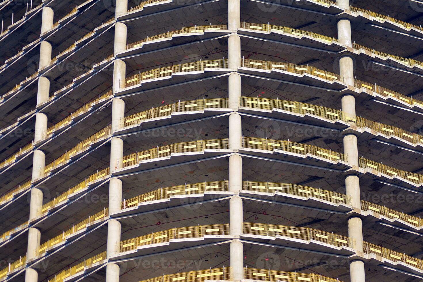 High rise building under construction. Installation of glass facade panels on a reinforced concrete structure. photo