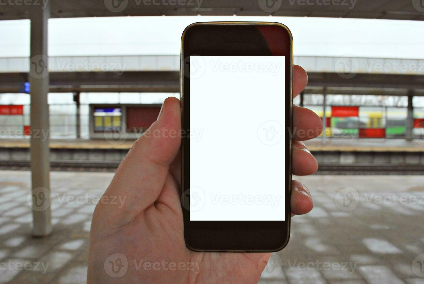 Hand holding smartphone with subway station background photo