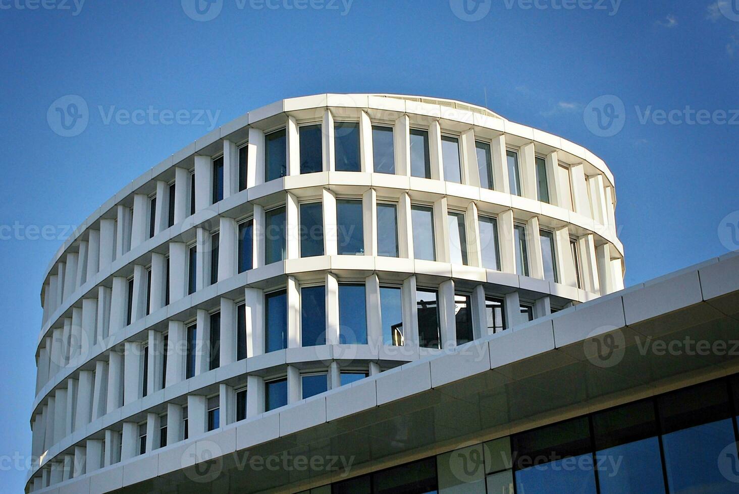 Abstract closeup of the glass-clad facade of a modern building covered in reflective plate glass. Architecture abstract background. Glass wall and facade detail. photo