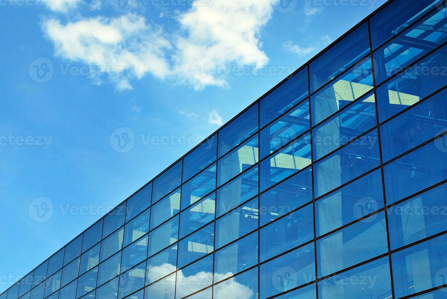 Glass building with transparent facade of the building and blue sky. Structural glass wall reflecting blue sky. photo
