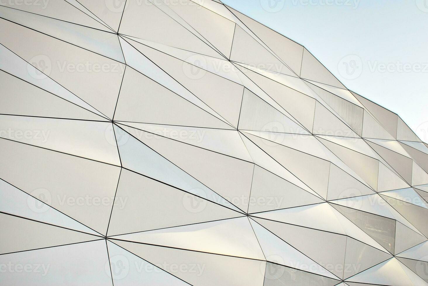 Abstract closeup of the glass-clad facade of a modern building covered in reflective plate glass. Architecture abstract background. Glass wall and facade detail. photo