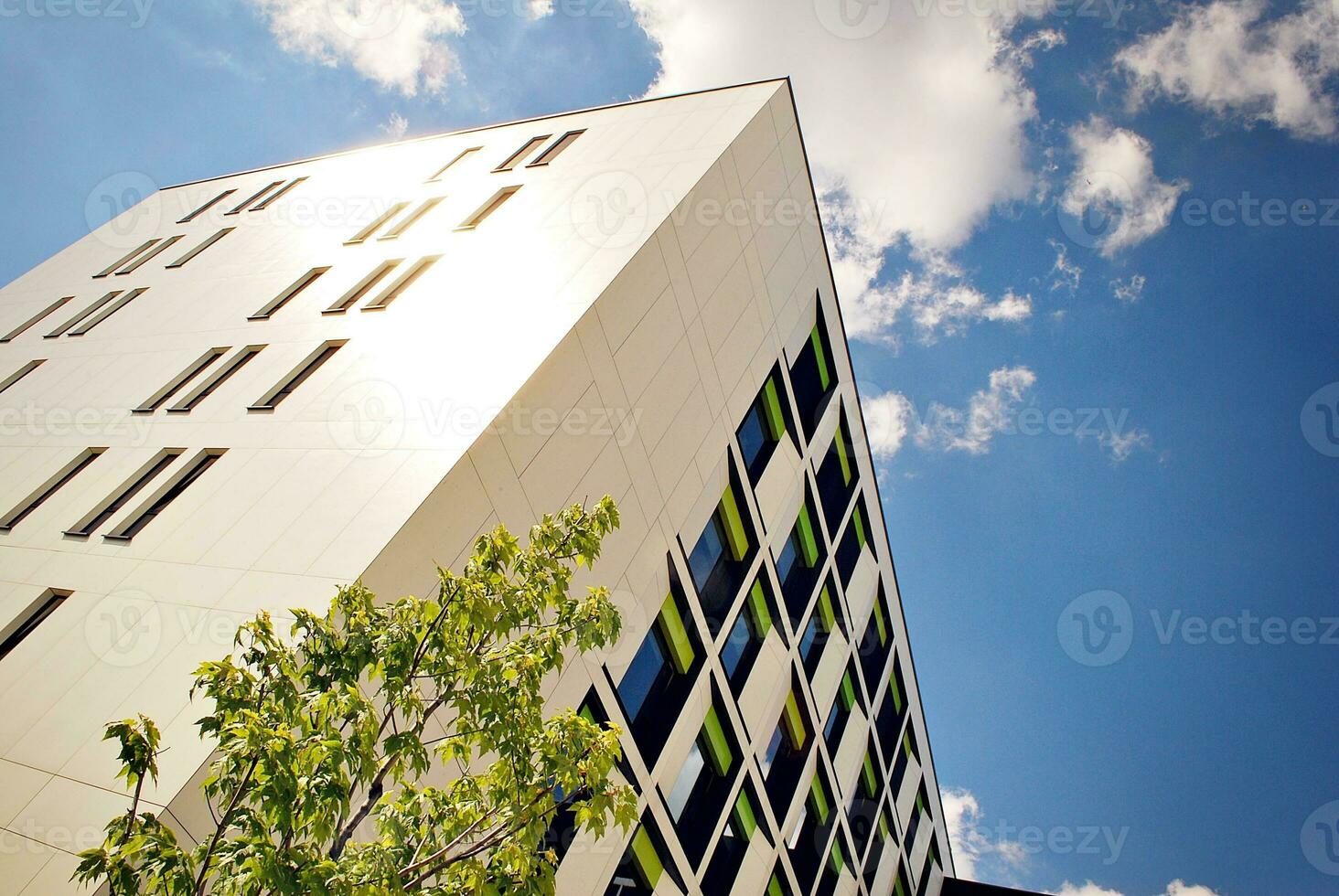 Abstract closeup of the glass-clad facade of a modern building covered in reflective plate glass. Architecture abstract background. Glass wall and facade detail. photo