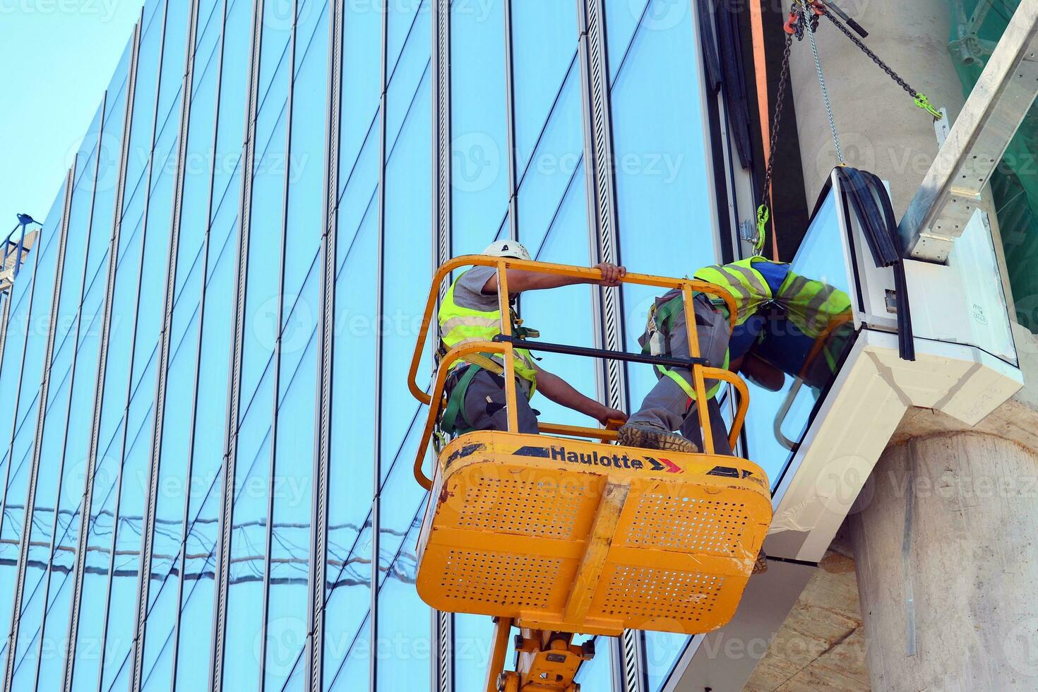 High rise building under construction. Installation of glass facade panels on a reinforced concrete structure. photo