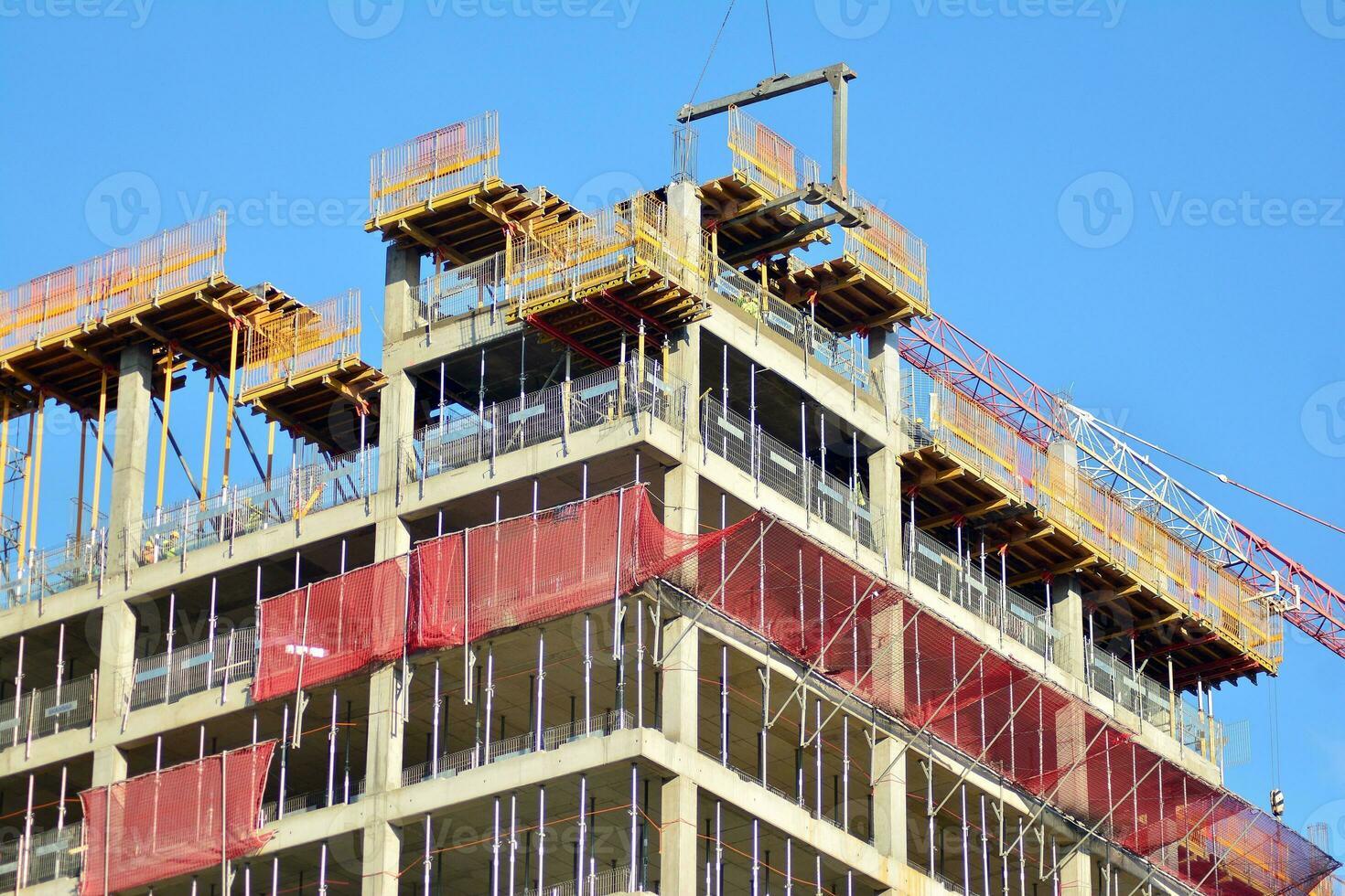 High rise building under construction. Installation of glass facade panels on a reinforced concrete structure. photo