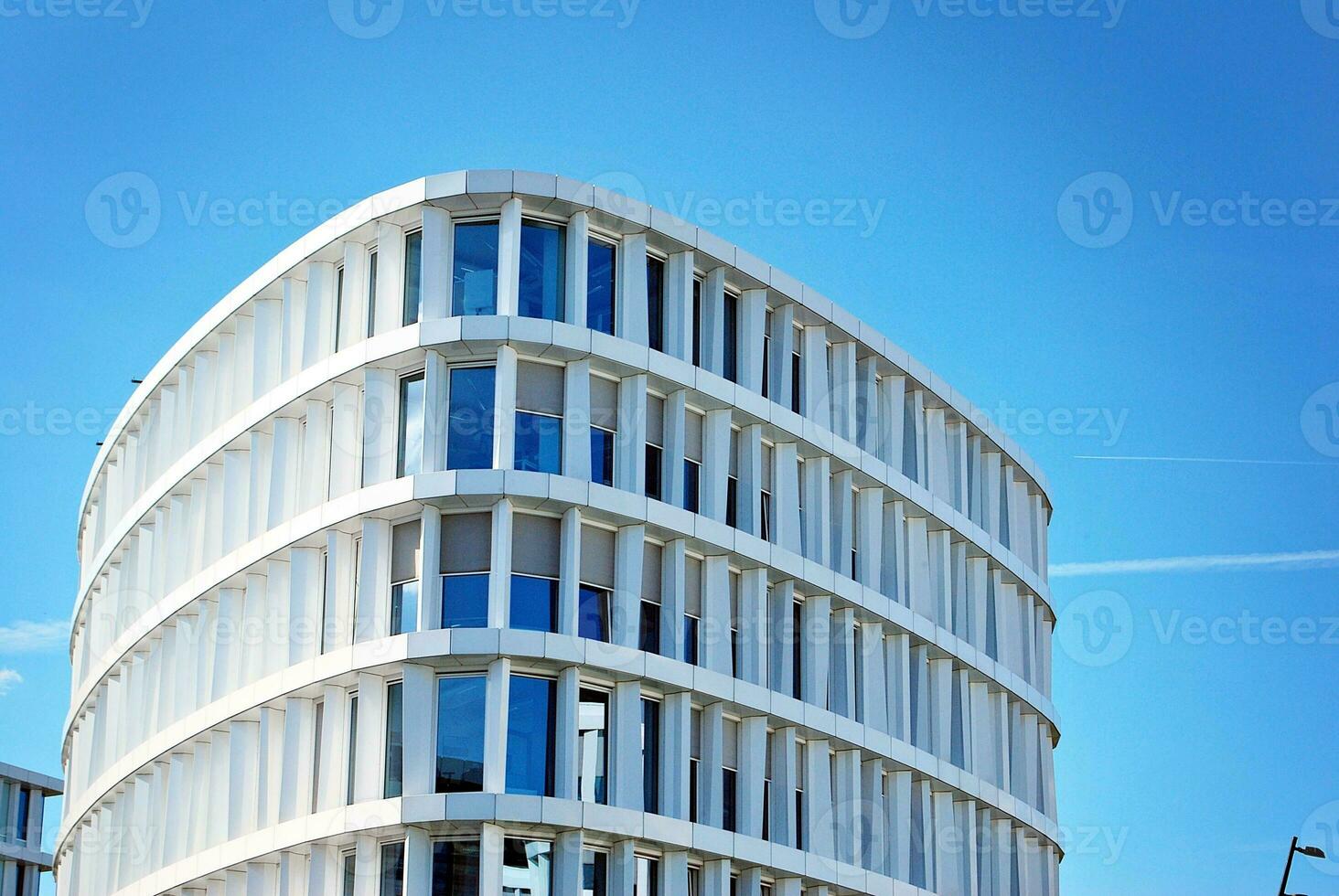 Abstract closeup of the glass-clad facade of a modern building covered in reflective plate glass. Architecture abstract background. Glass wall and facade detail. photo