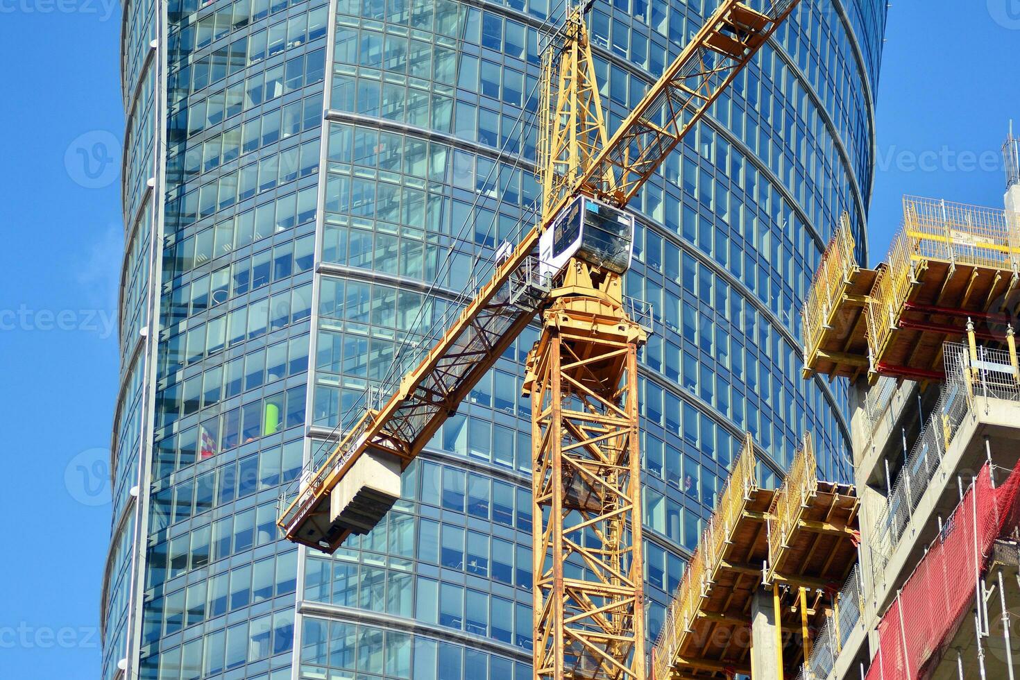 High rise building under construction. Installation of glass facade panels on a reinforced concrete structure. photo