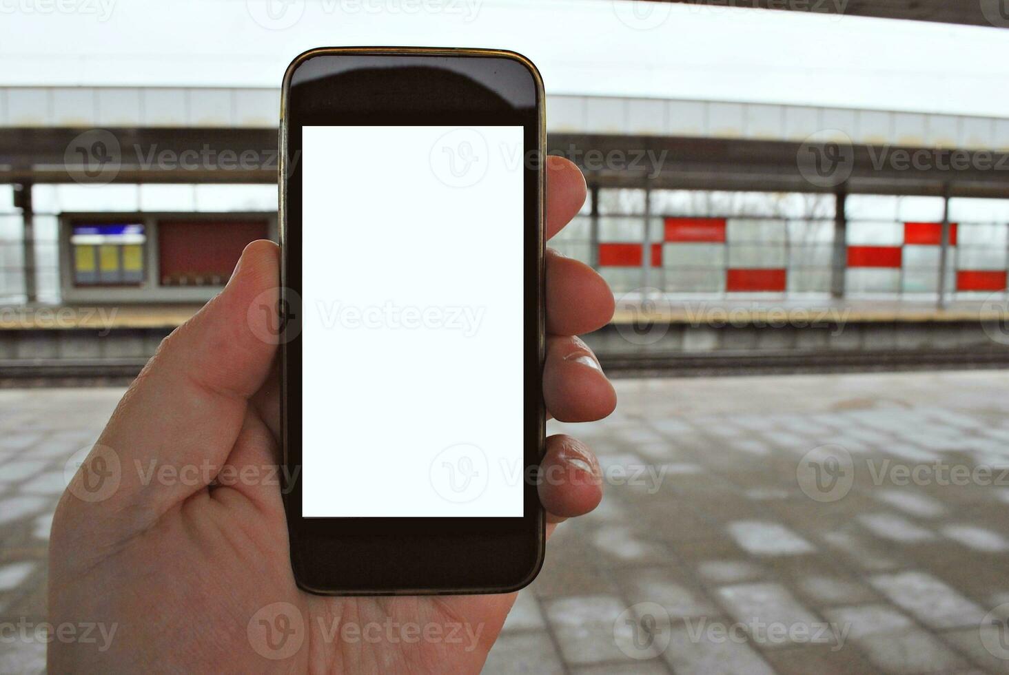 Hand holding smartphone with subway station background photo