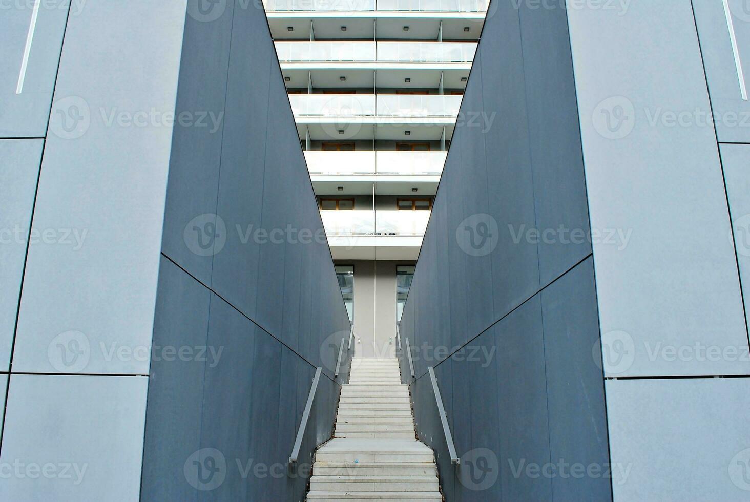 Abstract closeup of the glass-clad facade of a modern building covered in reflective plate glass. Architecture abstract background. Glass wall and facade detail. photo