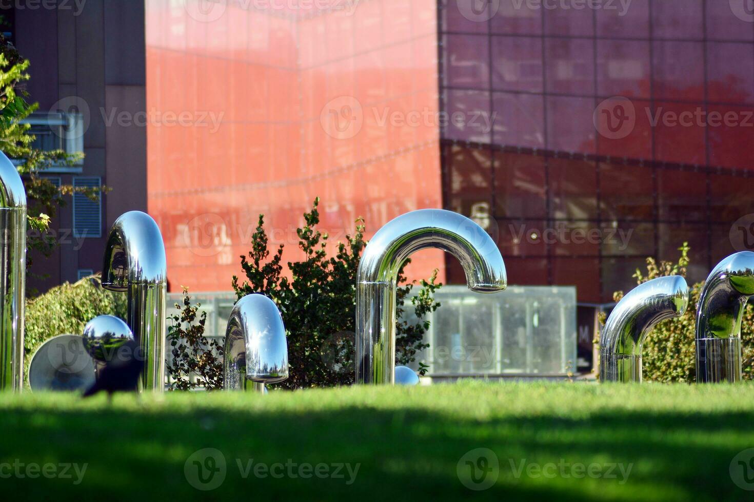 público Arte instalación en frente moderno edificio.decorativo inoxidable acero tubería foto