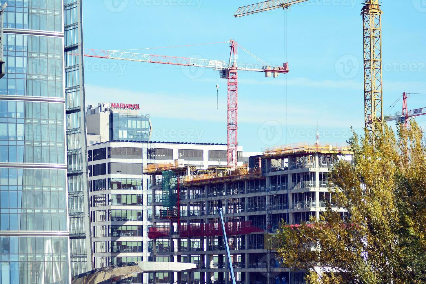 High rise building under construction. Installation of glass facade panels on a reinforced concrete structure. photo
