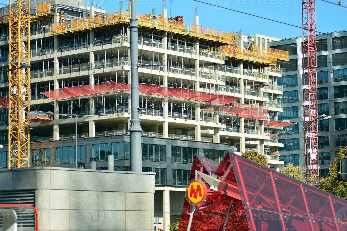 High rise building under construction. Installation of glass facade panels on a reinforced concrete structure. photo