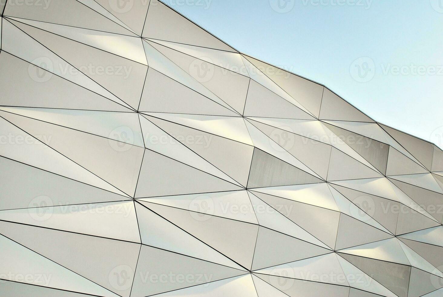Abstract closeup of the glass-clad facade of a modern building covered in reflective plate glass. Architecture abstract background. Glass wall and facade detail. photo