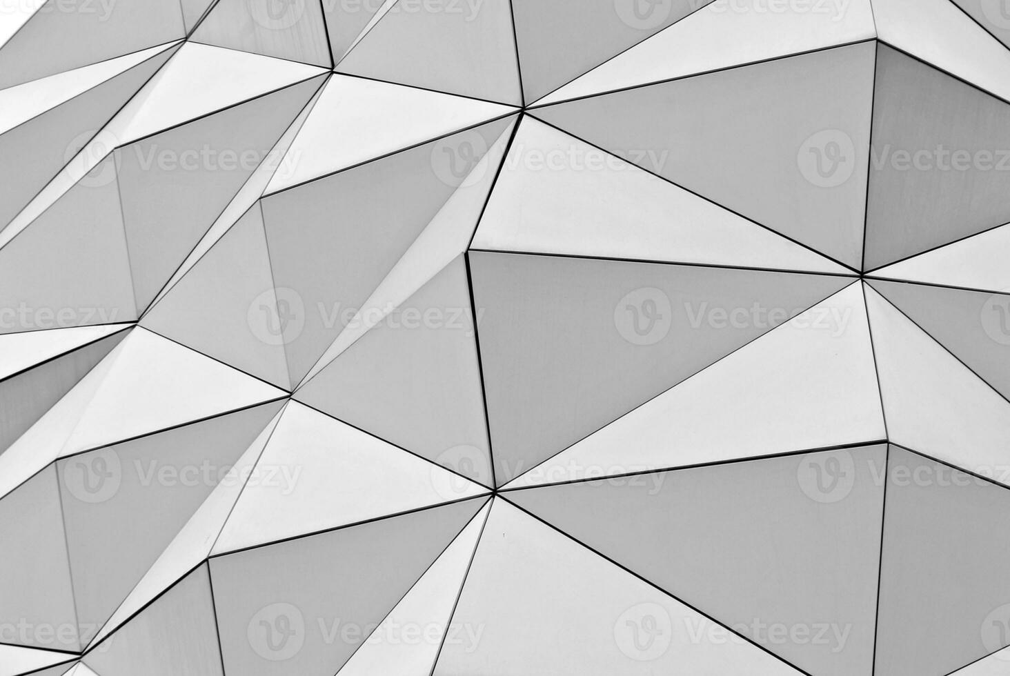 Abstract closeup of the glass-clad facade of a modern building covered in reflective plate glass. Architecture abstract background. Glass wall and facade detail. photo