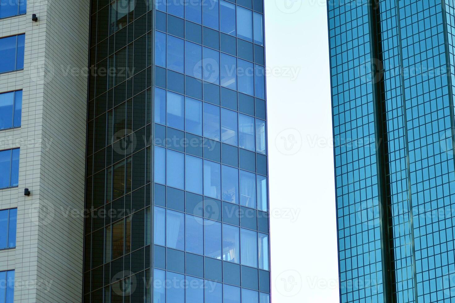 Glass building with transparent facade of the building and blue sky. Structural glass wall reflecting blue sky. Abstract modern architecture fragment. Contemporary architectural background. photo
