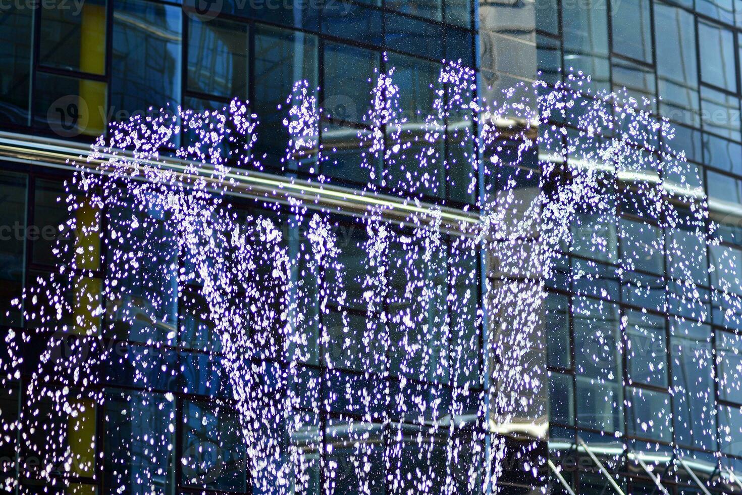 Glass building with transparent facade of the building and blue sky. Structural glass wall reflecting blue sky. Abstract modern architecture fragment. Contemporary architectural background. photo