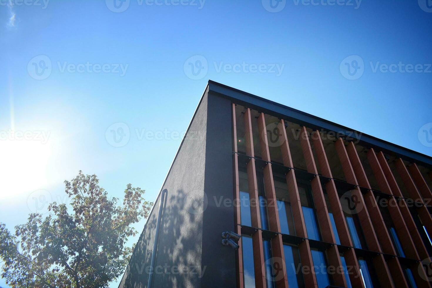 Abstract closeup of the glass-clad facade of a modern building covered in reflective plate glass. Architecture abstract background. Glass wall and facade detail. photo