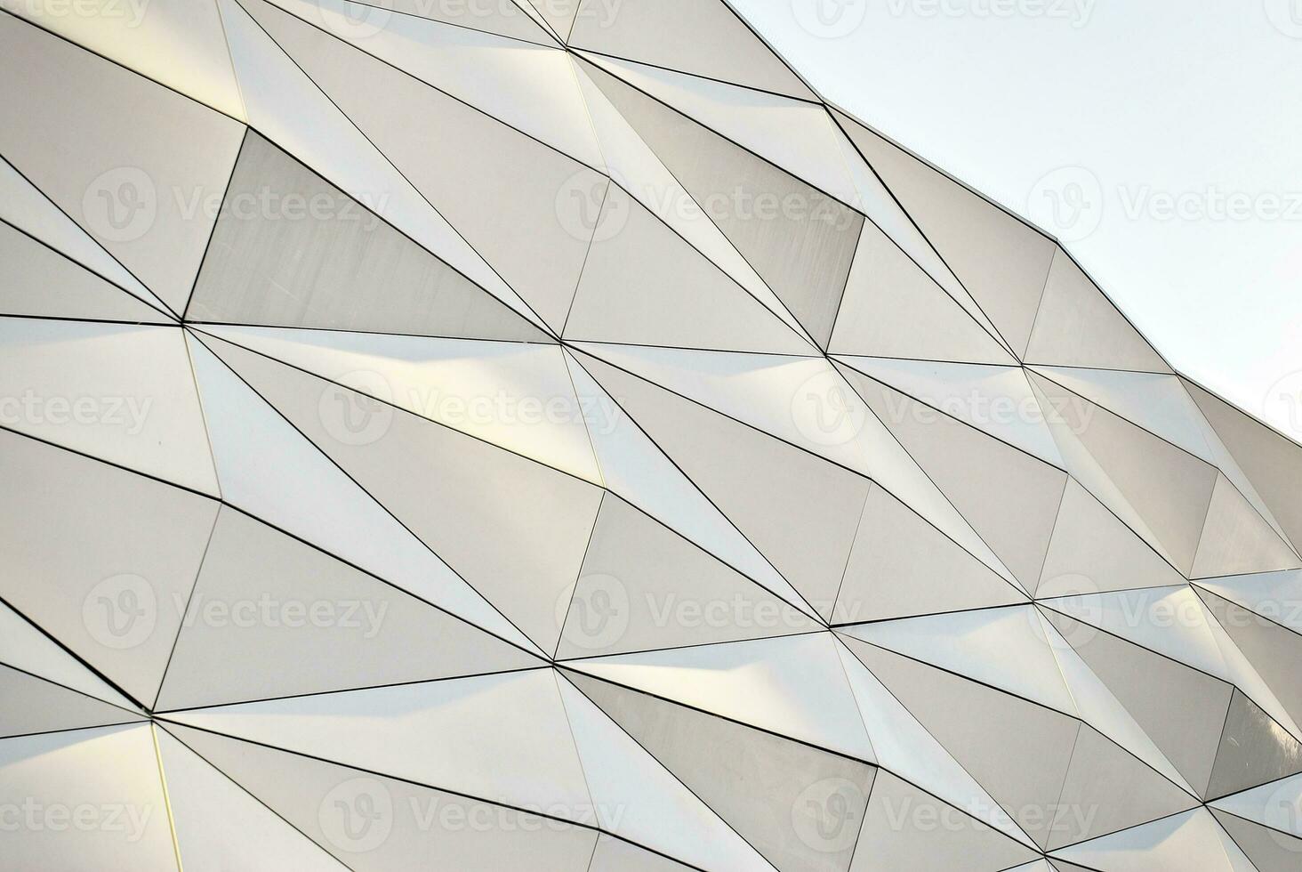 Abstract closeup of the glass-clad facade of a modern building covered in reflective plate glass. Architecture abstract background. Glass wall and facade detail. photo