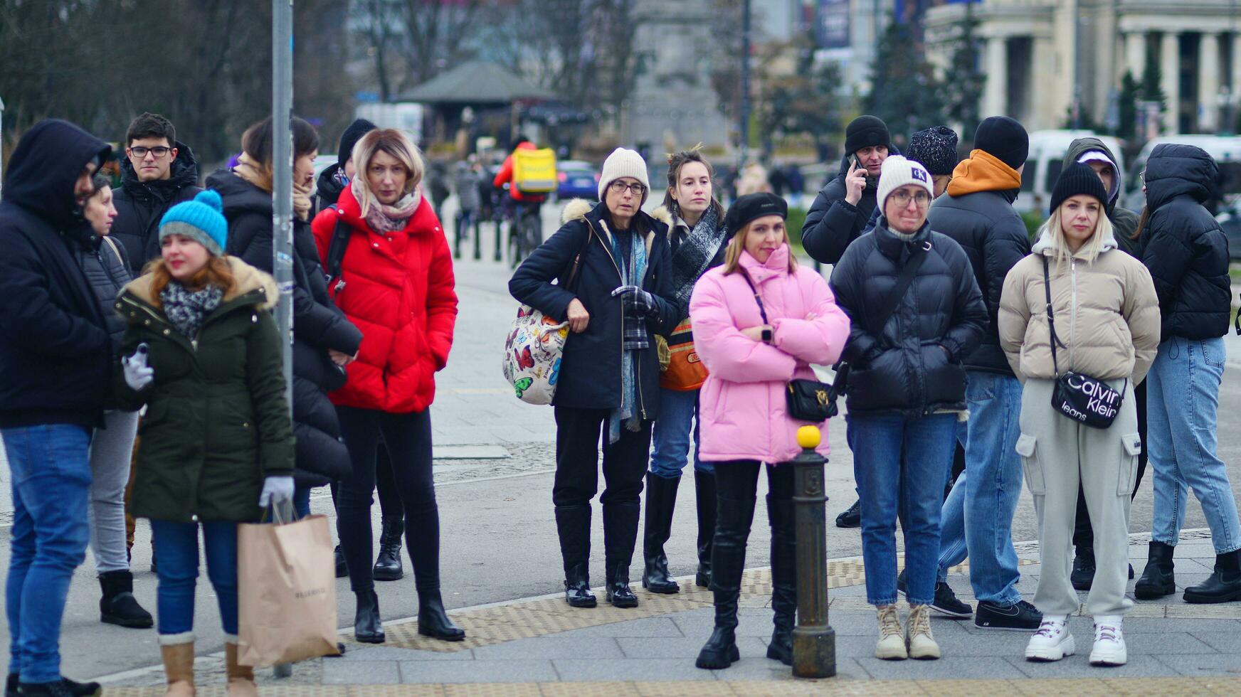 Warsaw, Poland. 29 December 2023. Crowd of people crossing street on traffic light zebra in the city  at rush hour. Lifestyle in a big city in Europa. photo