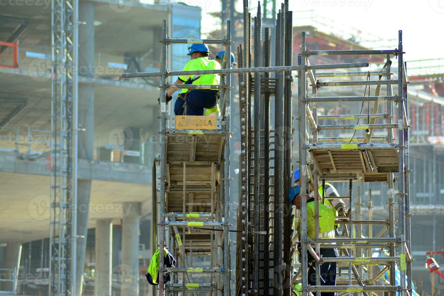 High rise building under construction. Installation of glass facade panels on a reinforced concrete structure. photo