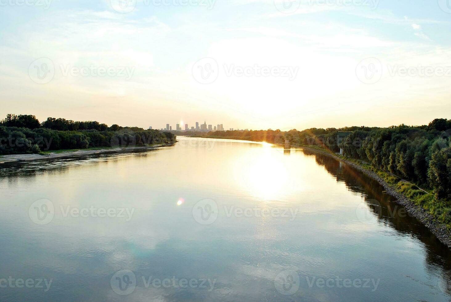 River in the city in at colorful sunset in the background photo