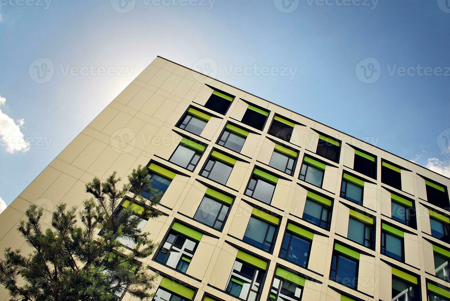 Abstract closeup of the glass-clad facade of a modern building covered in reflective plate glass. Architecture abstract background. Glass wall and facade detail. photo