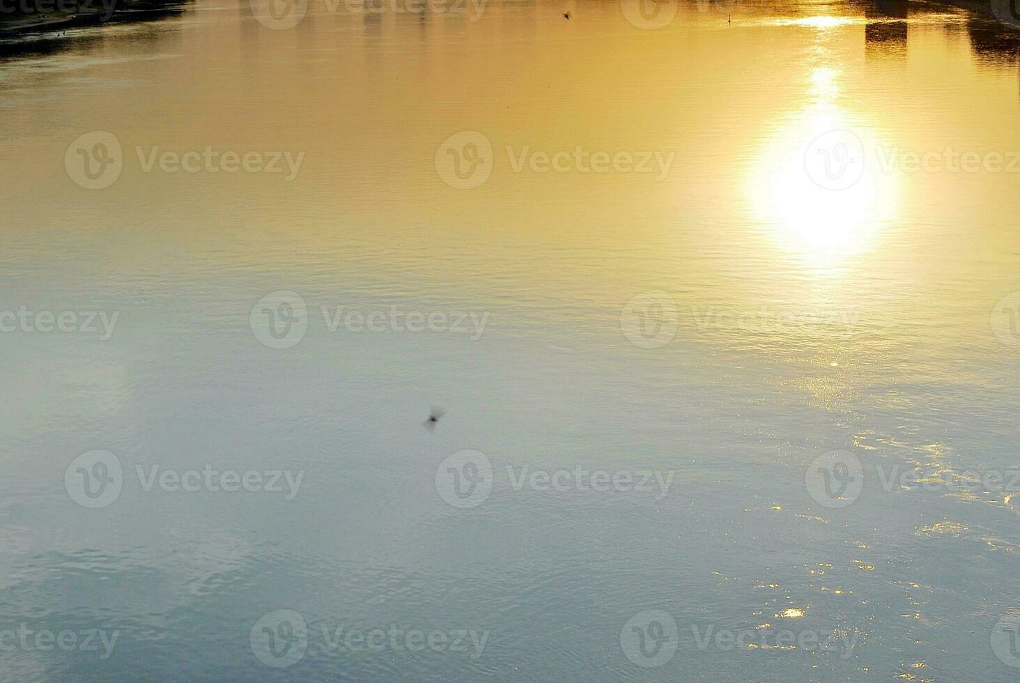 River in the city in at colorful sunset in the background photo