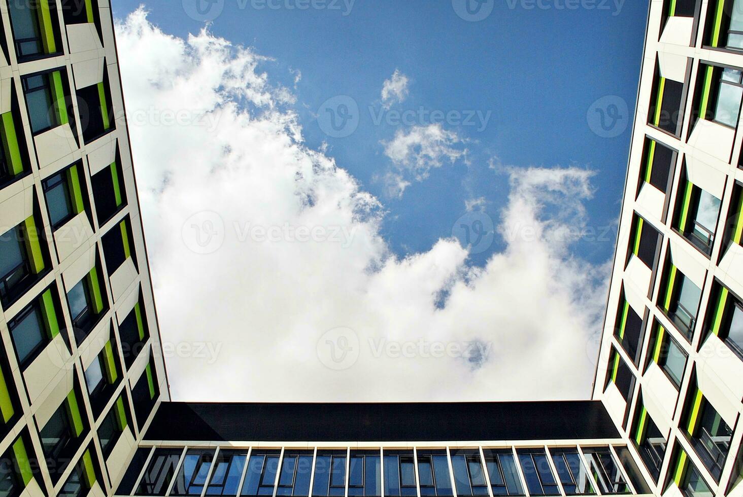 Abstract closeup of the glass-clad facade of a modern building covered in reflective plate glass. Architecture abstract background. Glass wall and facade detail. photo