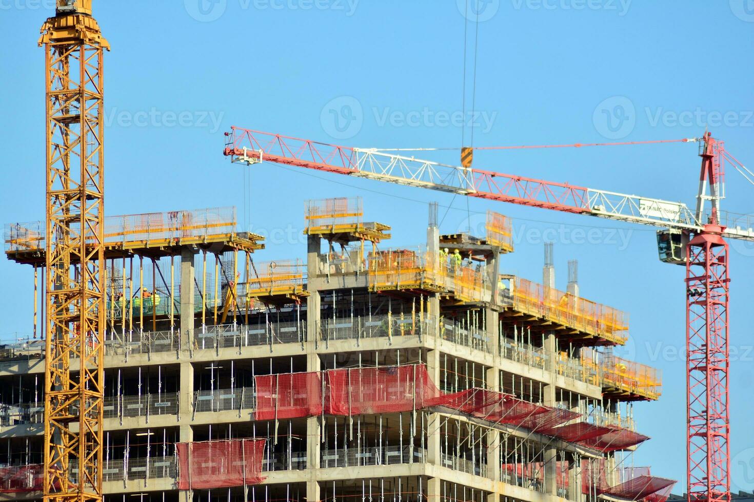 High rise building under construction. Installation of glass facade panels on a reinforced concrete structure. photo