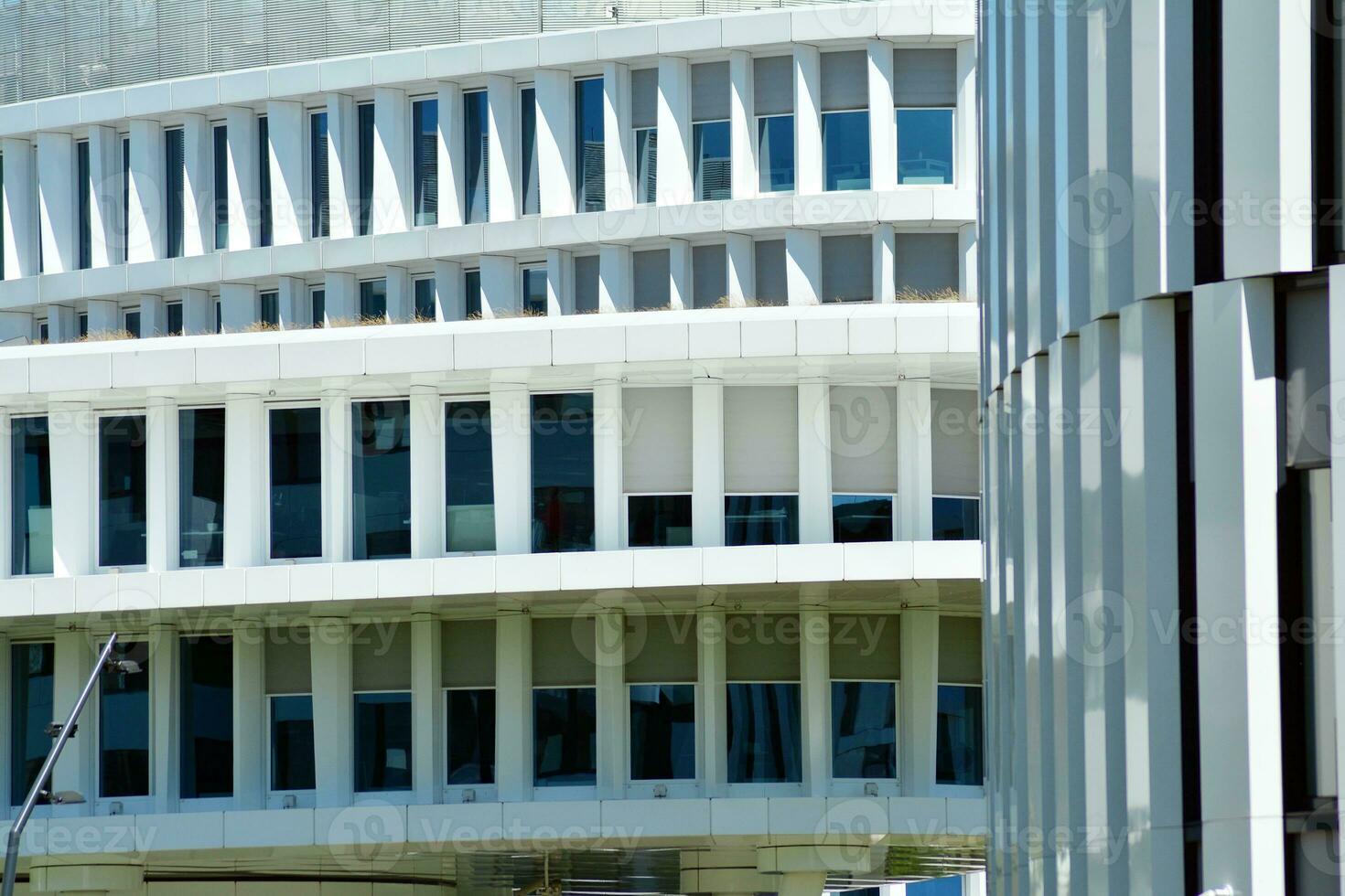 Abstract closeup of the glass-clad facade of a modern building covered in reflective plate glass. Architecture abstract background. Glass wall and facade detail. photo