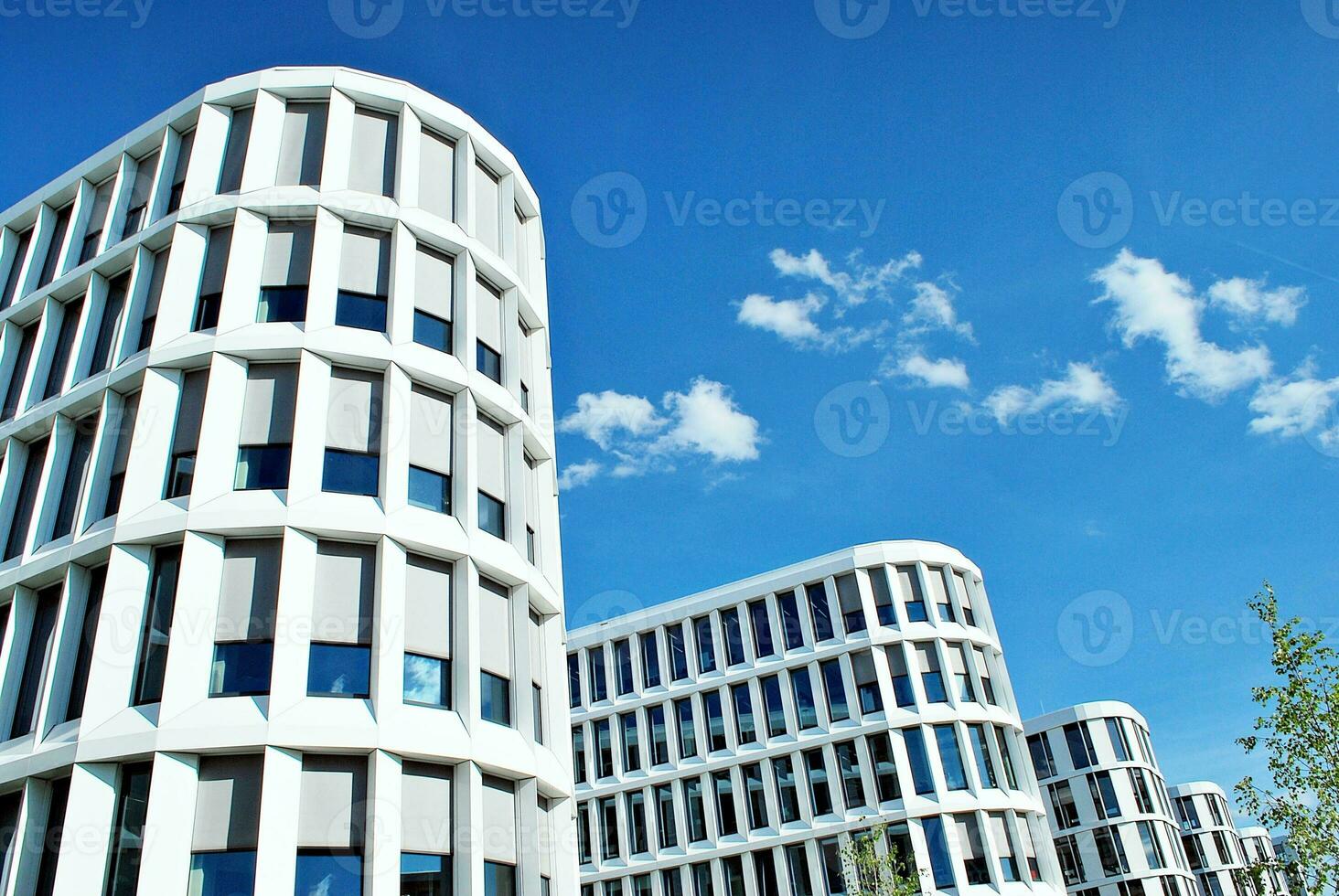 Abstract closeup of the glass-clad facade of a modern building covered in reflective plate glass. Architecture abstract background. Glass wall and facade detail. photo