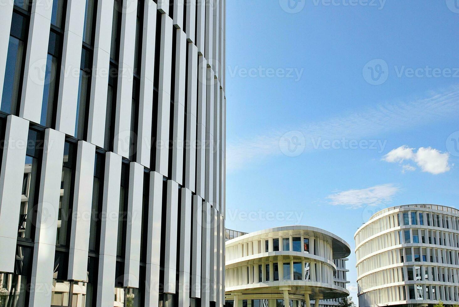 Abstract closeup of the glass-clad facade of a modern building covered in reflective plate glass. Architecture abstract background. Glass wall and facade detail. photo