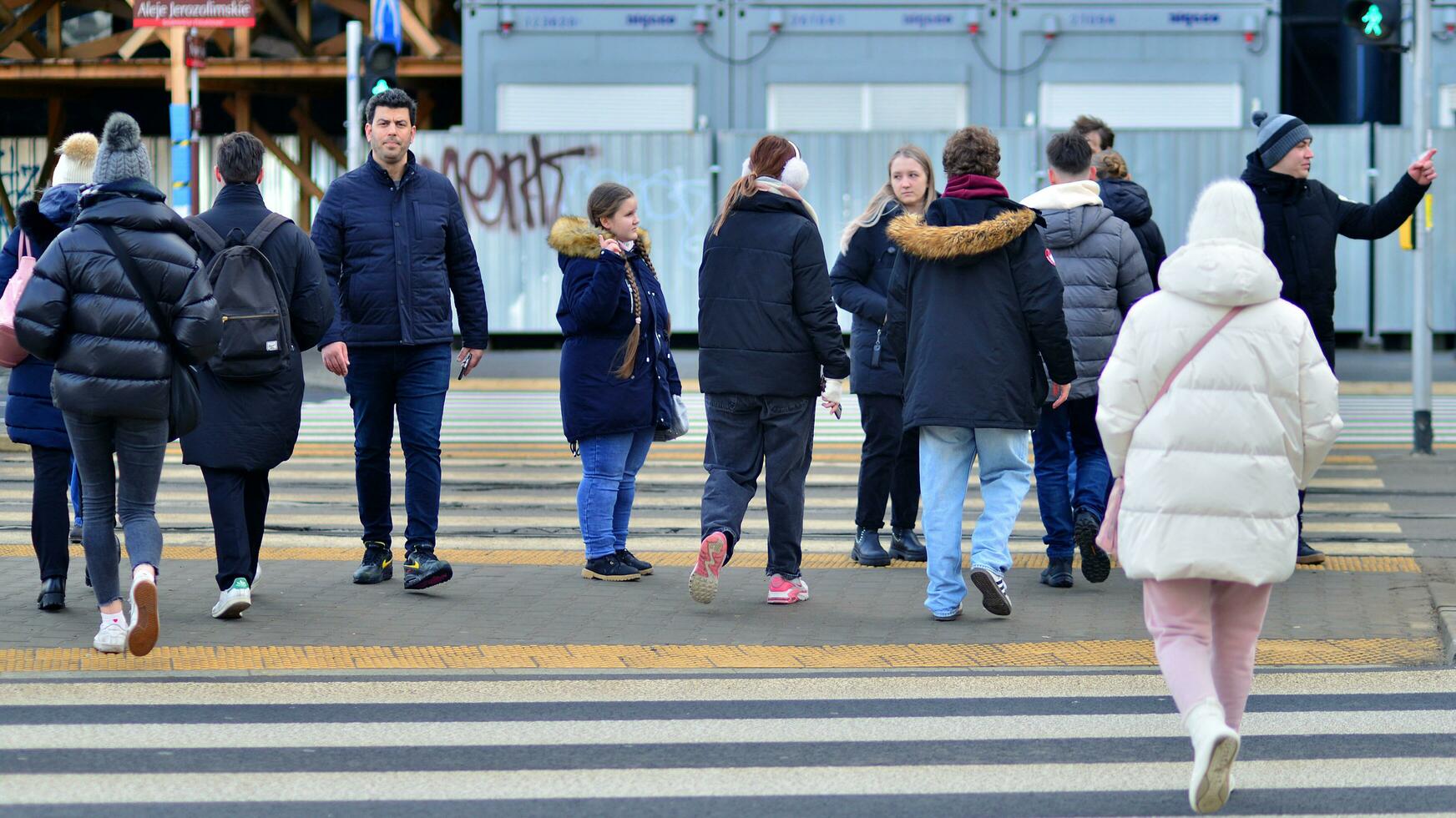 Warsaw, Poland. 29 December 2023. Crowd of people crossing street on traffic light zebra in the city  at rush hour. Lifestyle in a big city in Europa. photo