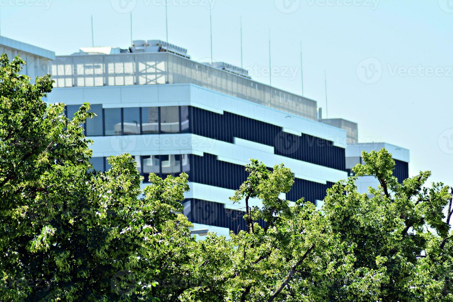 Abstract closeup of the glass-clad facade of a modern building covered in reflective plate glass. Architecture abstract background. Glass wall and facade detail. photo