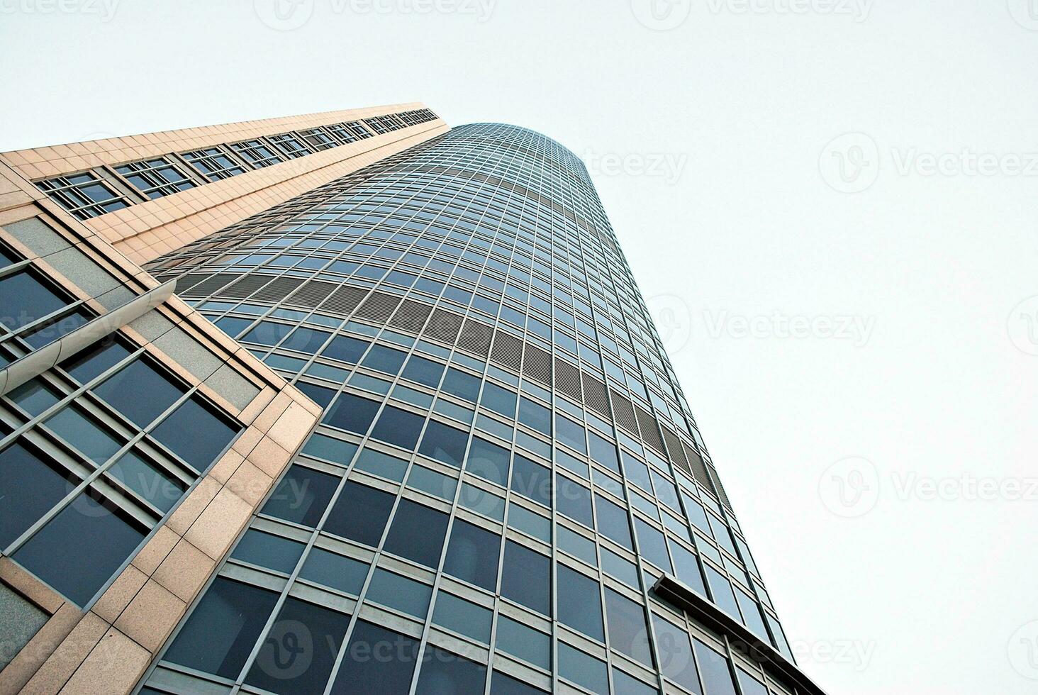 Abstract closeup of the glass-clad facade of a modern building covered in reflective plate glass. Architecture abstract background. Glass wall and facade detail. photo