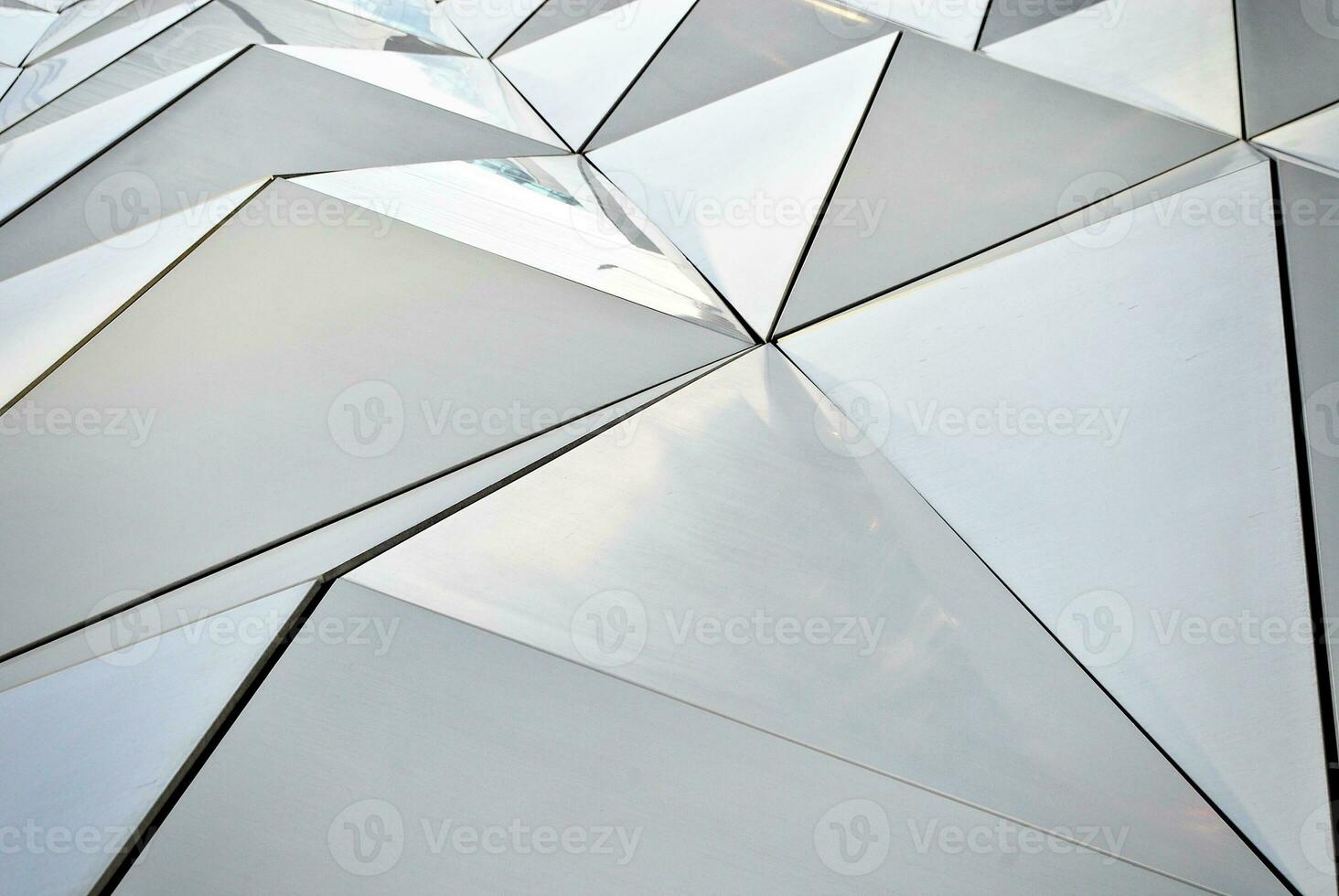 Abstract closeup of the glass-clad facade of a modern building covered in reflective plate glass. Architecture abstract background. Glass wall and facade detail. photo