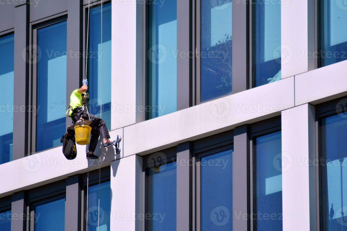 Abstract closeup of the glass-clad facade of a modern building covered in reflective plate glass. Architecture abstract background. Glass wall and facade detail. photo