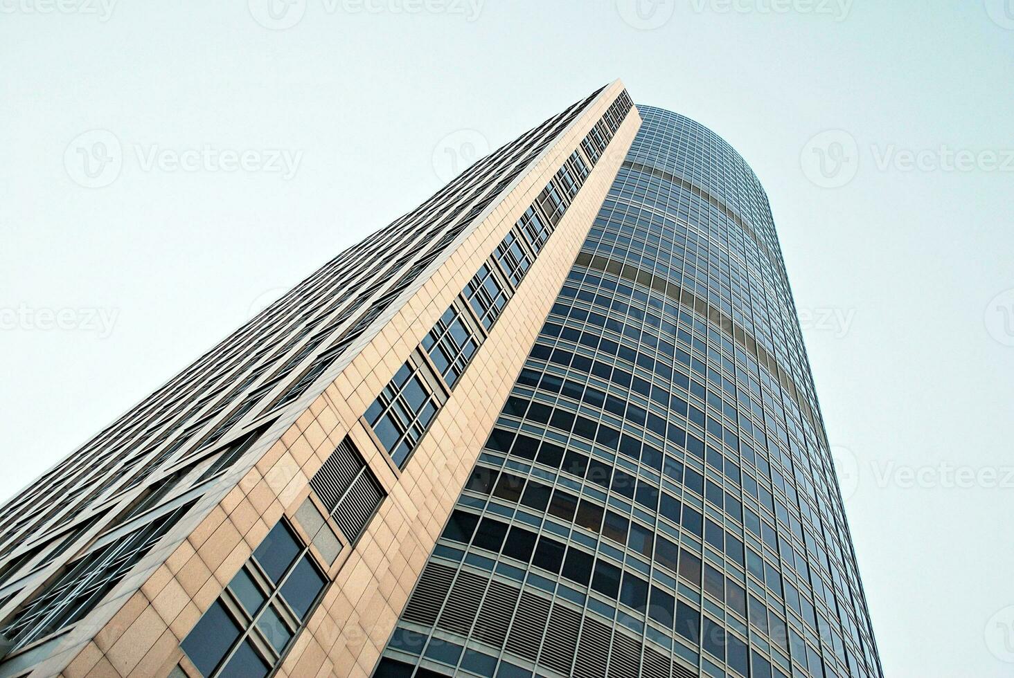 Abstract closeup of the glass-clad facade of a modern building covered in reflective plate glass. Architecture abstract background. Glass wall and facade detail. photo