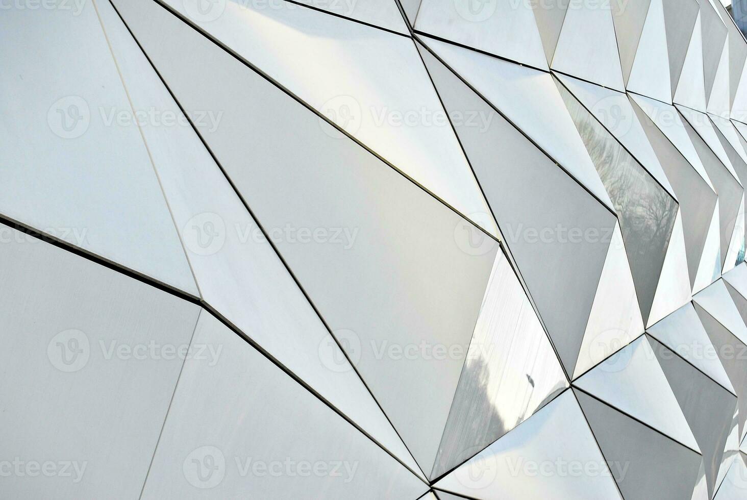 Abstract closeup of the glass-clad facade of a modern building covered in reflective plate glass. Architecture abstract background. Glass wall and facade detail. photo