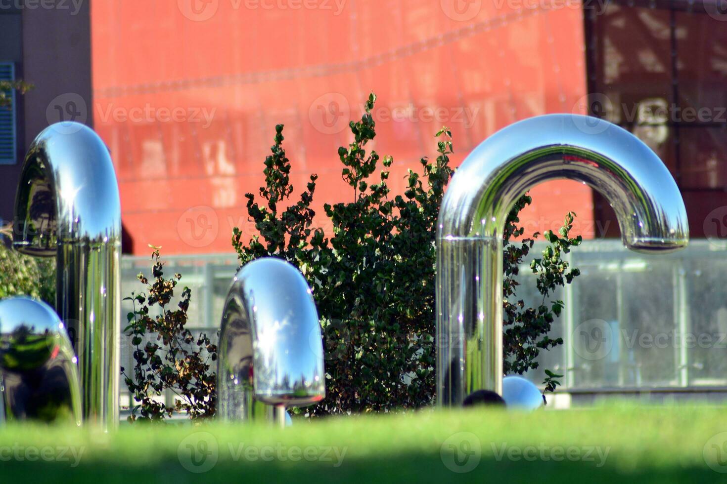 Public art installation in front modern building.Decorative stainless steel pipes photo