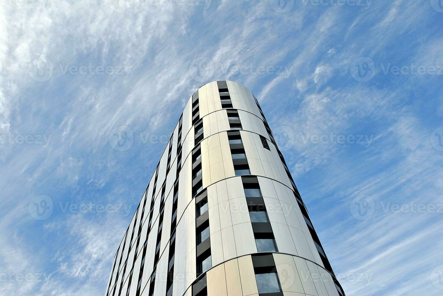 Abstract closeup of the glass-clad facade of a modern building covered in reflective plate glass. Architecture abstract background. Glass wall and facade detail. photo