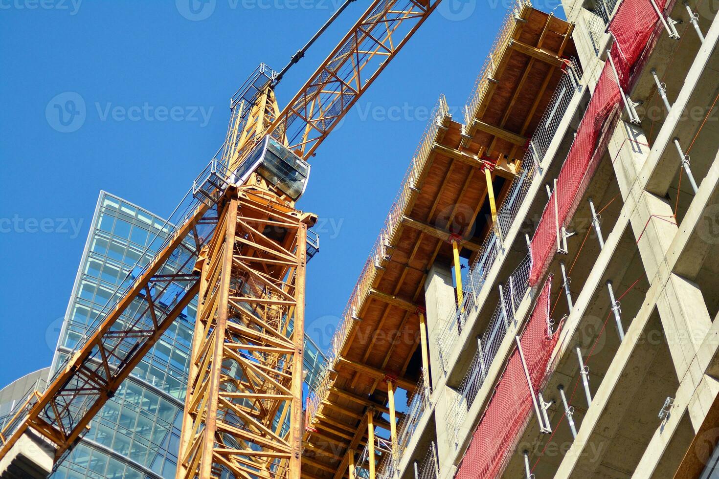 High rise building under construction. Installation of glass facade panels on a reinforced concrete structure. photo