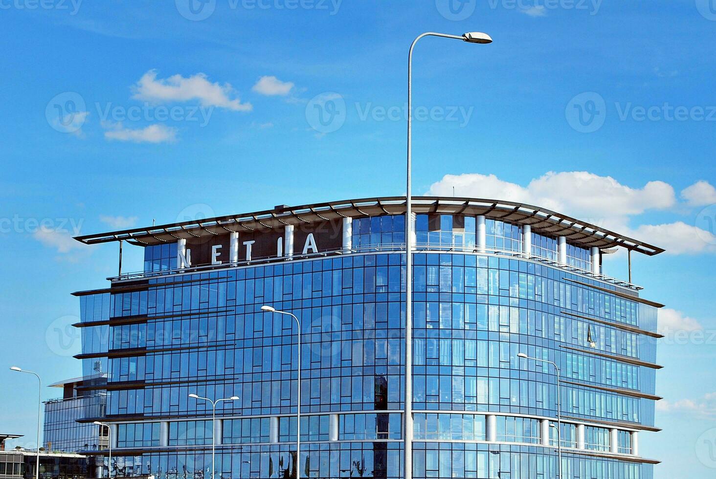 Glass building with transparent facade of the building and blue sky. Structural glass wall reflecting blue sky. Abstract modern architecture fragment. Contemporary architectural background. photo