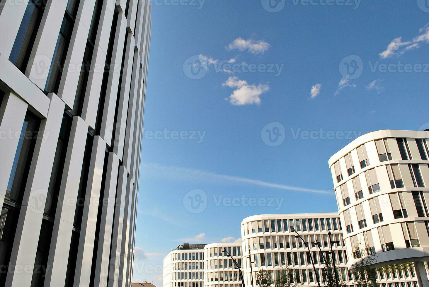 Abstract closeup of the glass-clad facade of a modern building covered in reflective plate glass. Architecture abstract background. Glass wall and facade detail. photo