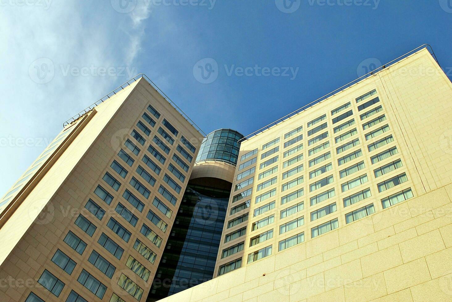 Abstract closeup of the glass-clad facade of a modern building covered in reflective plate glass. Architecture abstract background. Glass wall and facade detail. photo