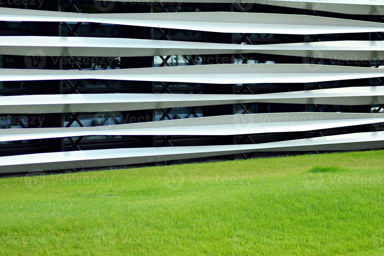 Abstract closeup of the glass-clad facade of a modern building covered in reflective plate glass. Architecture abstract background. Glass wall and facade detail. photo
