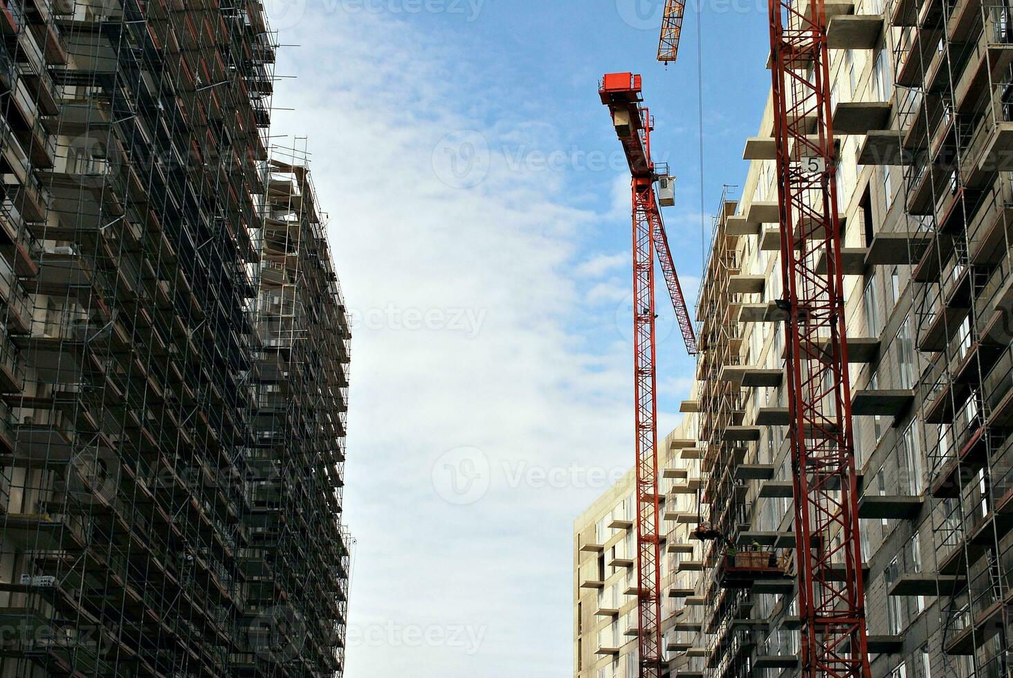 High rise building under construction. Installation of glass facade panels on a reinforced concrete structure. photo